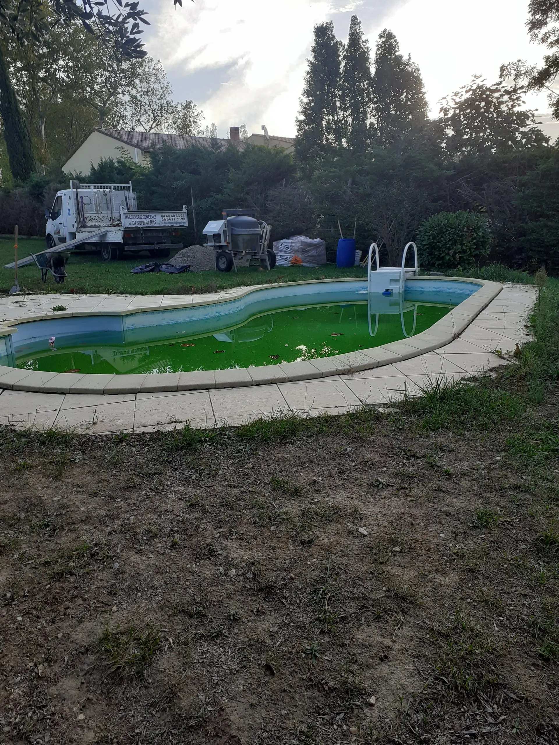 Préparation d’un chantier d’aménagement autour d’une piscine avec camion et bétonnière.