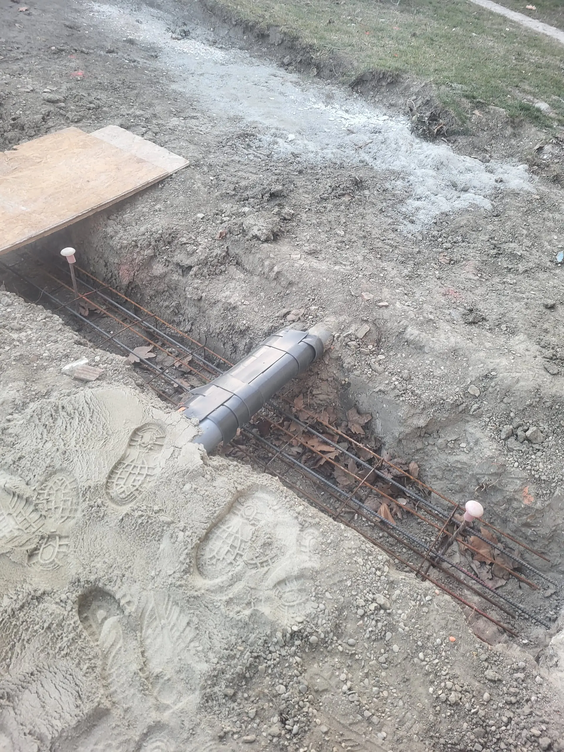 Ferraillage de fondations avec passage d’un conduit dans une tranchée de chantier.