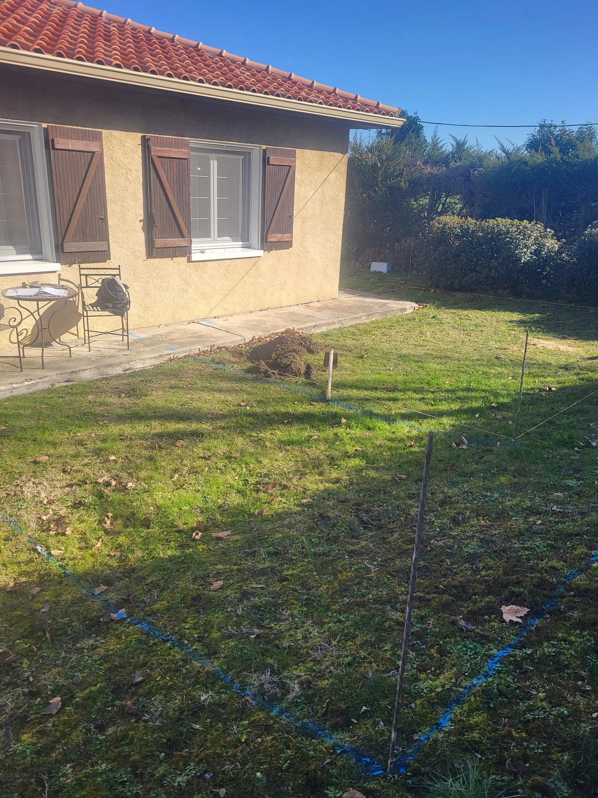 Tracé d’implantation d’un ouvrage de maçonnerie dans le jardin d’une maison.