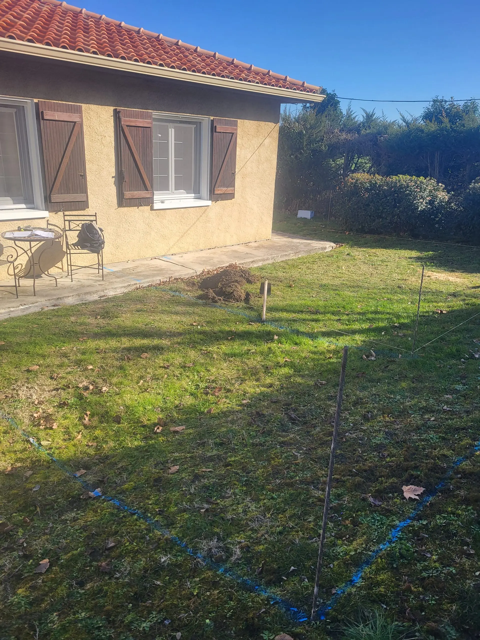 Traçage d’implantation d’un ouvrage de maçonnerie dans le jardin d’une maison.