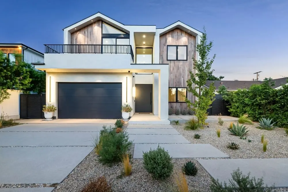 Maison contemporaine à deux niveaux avec façade claire, bardage bois et garage.
