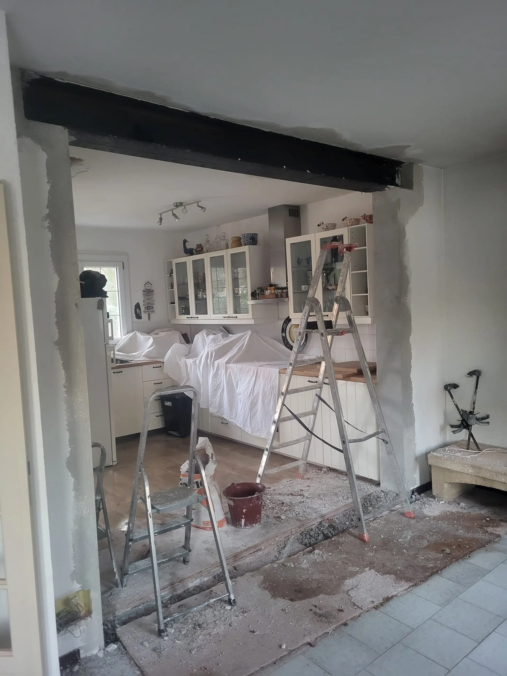 Ouverture de mur renforcée par une poutre métallique lors d’une rénovation intérieure.